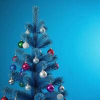 Blue Christmas tree adorned with snowflakes and baubles against a blue backdrop photo