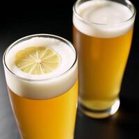 A Hefeweizen glass holds a hazy golden beer while another is garnished photo