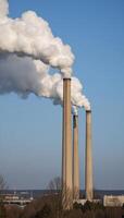 Emission of CO2 from coalfired power plants into the atmosphere showcasing air pollution caused by smokestacks and their environmental impact on ecology photo