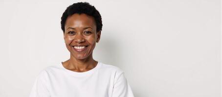 A proud African American senior woman stands against a white backdrop wearing a white Tshirt for ad placement photo