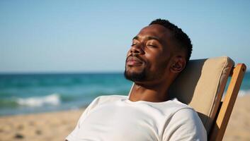 African American man relaxing at the beach with a reclined posture and soaking up the sun photo