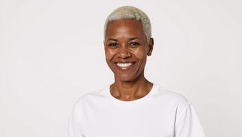 A proud African American senior woman stands against a white backdrop wearing a white Tshirt for ad placement photo