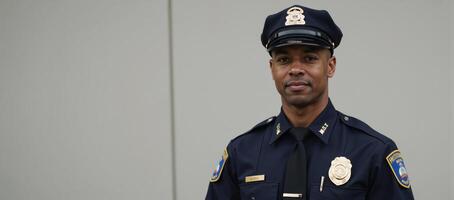 Portrait of an African American police officer in uniform against a blurry backdrop photo