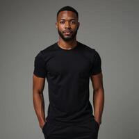 A confident AfricanAmerican model showcases the flexibility of a fitted black tee on a neutral backdrop photo