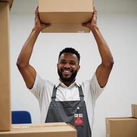 African American man smiles while loading boxes at a cleanuniformed warehouse photo