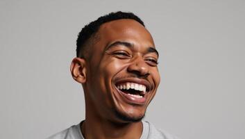 Closeup portrait of a joyful Black man laughing against a gray backdrop photo