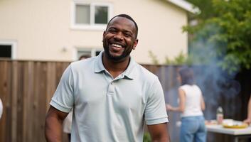 Closeup portrait of an African American man smiling while grilling food at a backyard barbeque photo