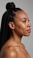A beautiful Black African American woman with curly long braids and a bun displaying a perfect facial structure including a striking sharply defined jawline as she looks to the left in a side profile photo