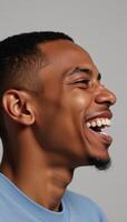 Closeup portrait of a joyful Black man laughing against a gray backdrop photo