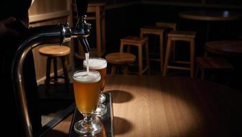 Image portrays pouring beer from tap at a bar setting photo