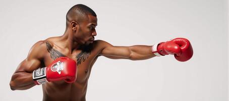 A powerful AfricanAmerican boxer with a painted body throws a punch using red boxing gloves photo