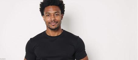 A confident African American man with an Afro wears a black shirt and displays a calm expression Copy Space photo