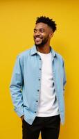 A cool stylish Gen Z black hipster stands on a bright yellow backdrop gazing off into ad space with a happy expression photo