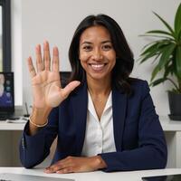 Friendly African American businesswoman leads online meeting from her office with a wave on a call Online Business Digital Meeting photo