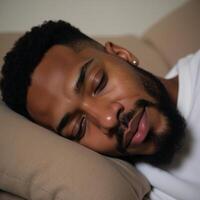 Closeup portrait of peaceful mindful man African American asleep on cozy couch photo