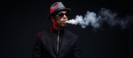 Stylized male figure dons hat sunglasses against a black backdrop illuminated by neon lighting as he vapes in a studio setting the image is highlighted by white accents photo