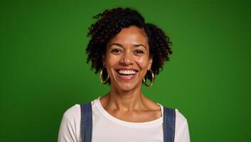 Portrait of a happy middleaged African American woman with quirky expressions against green background photo
