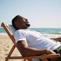 African American man relaxing at the beach with a reclined posture and soaking up the sun photo
