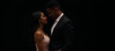 Against a backdrop of pure black an isolated AfricanAmerican couple dates photo