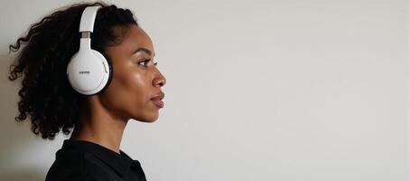 African American woman DJ seen from side listening to music while wearing headphones photo