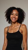 Confident pose by a beautiful African American woman with vibrant curls bright smile and soft natural lighting against a neutral backdrop photo