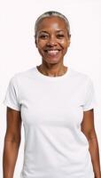 A proud African American senior woman stands against a white backdrop wearing a white Tshirt for ad placement photo