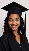 A cheerful young AfricanAmerican graduate smiles in her black graduation cap and tunic looking directly at the camera photo