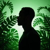 AfricanAmerican man profile with tropical plants in papercut style showcasing an interplay between human and nature rendered primarily in shades of green photo