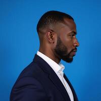 Human side view profile portrait of serious African American man against blue studio background photo