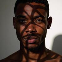 Closeup portrait of an African American man showcasing shadowy facial details and distinct striped patterns across his visage photo