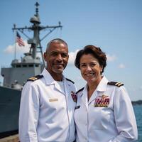A veteran AfricanAmerican Navy Officer stands proudly with spouse by warship beneath the American flag on Veterans Day photo