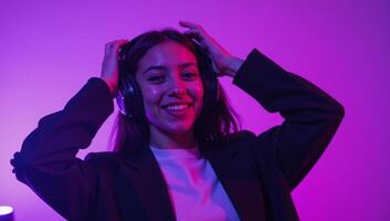 Trendy AfricanAmerican teenager dancing and listening to music under violet lights photo