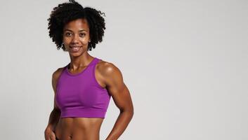 An African American fitness model showcases defined abs while wearing a purple shirt photo