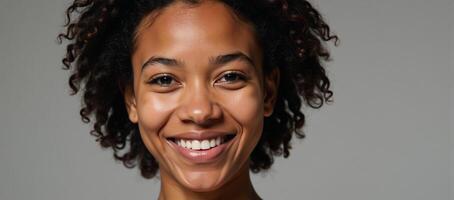 Closeup photo of a young Black woman with curls and a gentle smile