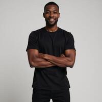 African American male model poses in a blank black tee perfect for logodesign placement on a neutral backdrop photo