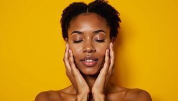African American woman with closed eyes touchingly portrait on yellow backdrop with natural makeup photo