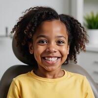 A joyful African American child is depicted during her dental visit for cleaning and examination featuring a radiant posttreatment smile with bright gleaming teeth photo