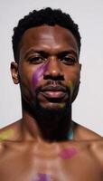 A handsome AfricanAmerican male exhibiting complex feelings illuminated by vibrant abstract lighting photo