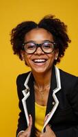 Cheerful AfricanAmerican girl with large glasses exudes confidence amidst a bright yellow backdrop her infectious grin and unique flair convey happiness and selfexpression photo