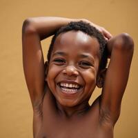 African American boy bursting with happiness grinning widely as he rises up from a seated position photo