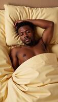 AfricanAmerican man lying on fabric bed photo