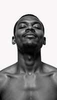 A blackandwhite double exposure portrait showcases a serene African American man sitting within a forest backdrop against a stark white background his closed eyes convey an air of contemplative peace photo