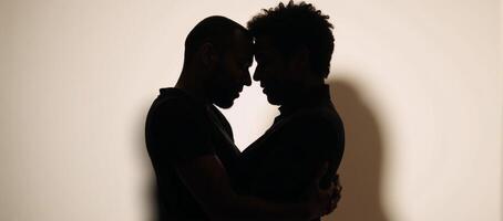 Concept Interracial gay couple on Valentines Day Asian and African American men expressing affection through an embrace in silhouette photo