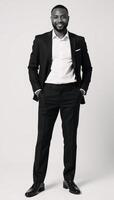 A confident African American businessman poses formally against a pure white backdrop photo