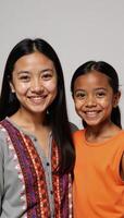 A cute smiling Native American teenager and an adorable AfricanAmerican girl share the space in the image photo