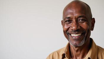 An African American old man with a warm smile stands alone against a white backdrop as a farmworker photo