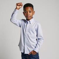 A confident AfricanAmerican boy stands proudly against an expressive backdrop fist raised photo