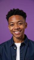 A confident African American teen boy exudes joy and style while beaming brightly against a vibrant purple studio backdrop symbolizing educational empowerment and youthful energy photo