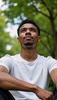 An introspective AfricanAmerican collegian contemplates under a clear sky photo