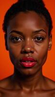 Closeup portrait of an African American woman wearing red lipstick against an orange background photo